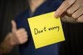 Man holds yellow sticker inscription DonÃ¢â¬â¢t worry Royalty Free Stock Photo